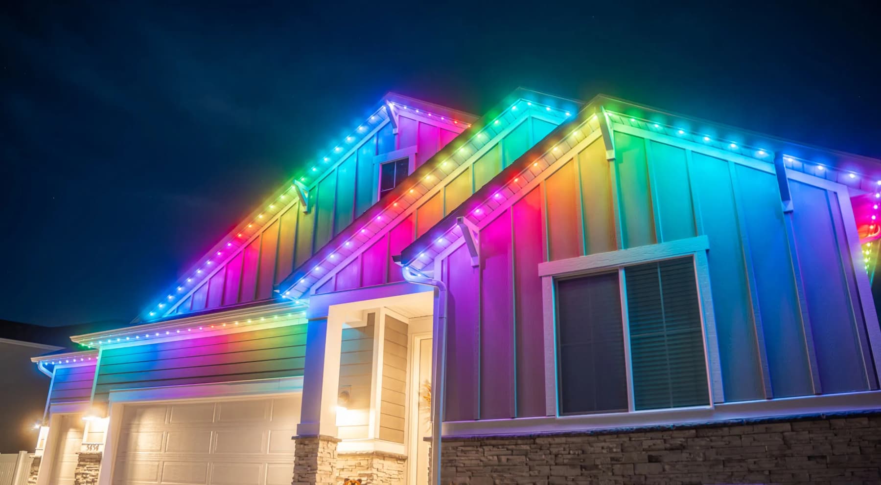 Wide view of a completed permanent LED lighting install across a full roofline