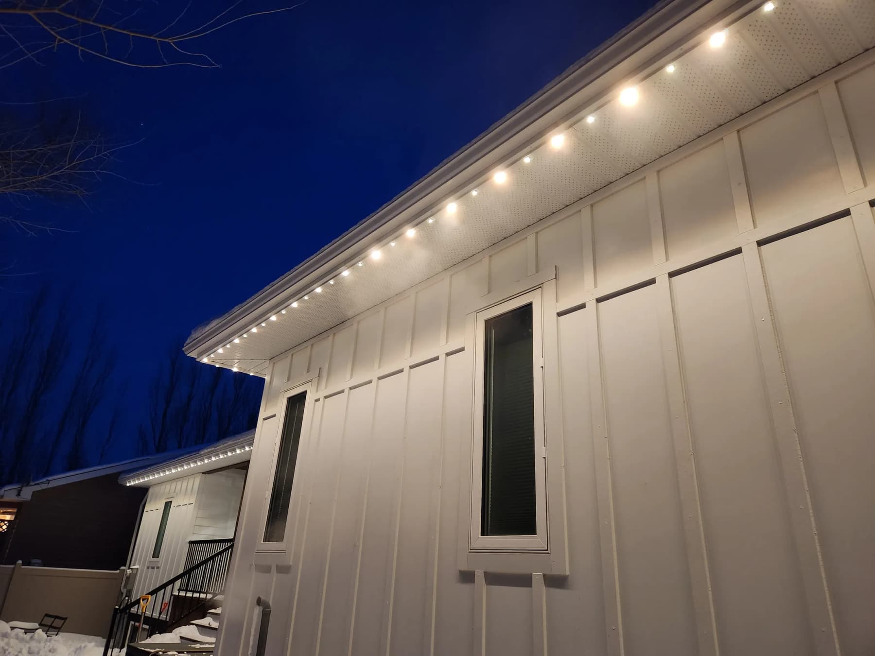 Close-up of RGBW LED puck lights seated in an aluminum soffit track