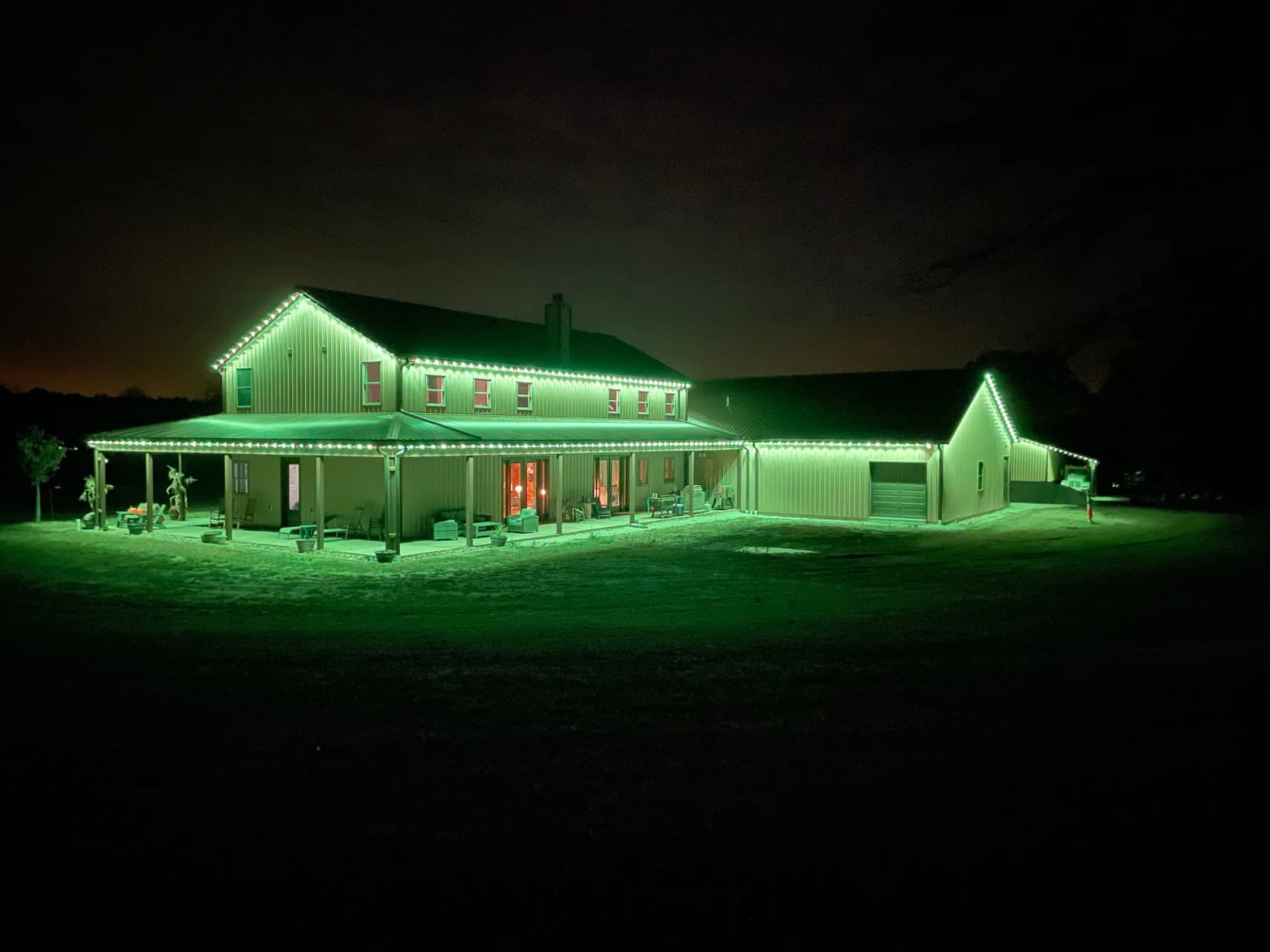 Soffit LED track lighting glowing green along a home's rooflines
